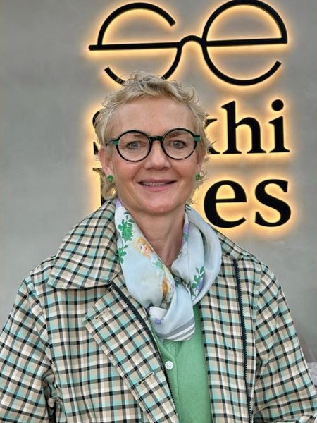 Guest in round green-rimmed frames